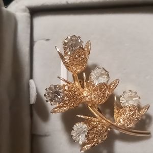 Vintage Flower brooch with clear rhinestones buds gold tone filagree pedals.